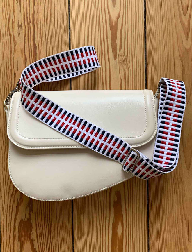 Taschengurt an weißer Handtasche